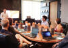 Exploring Knowledge Management Examples That Can Streamify Your Business A team in an office discussing knowledge management during a meeting